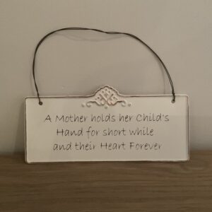 Tekstbordje “A mother holds her child’s…